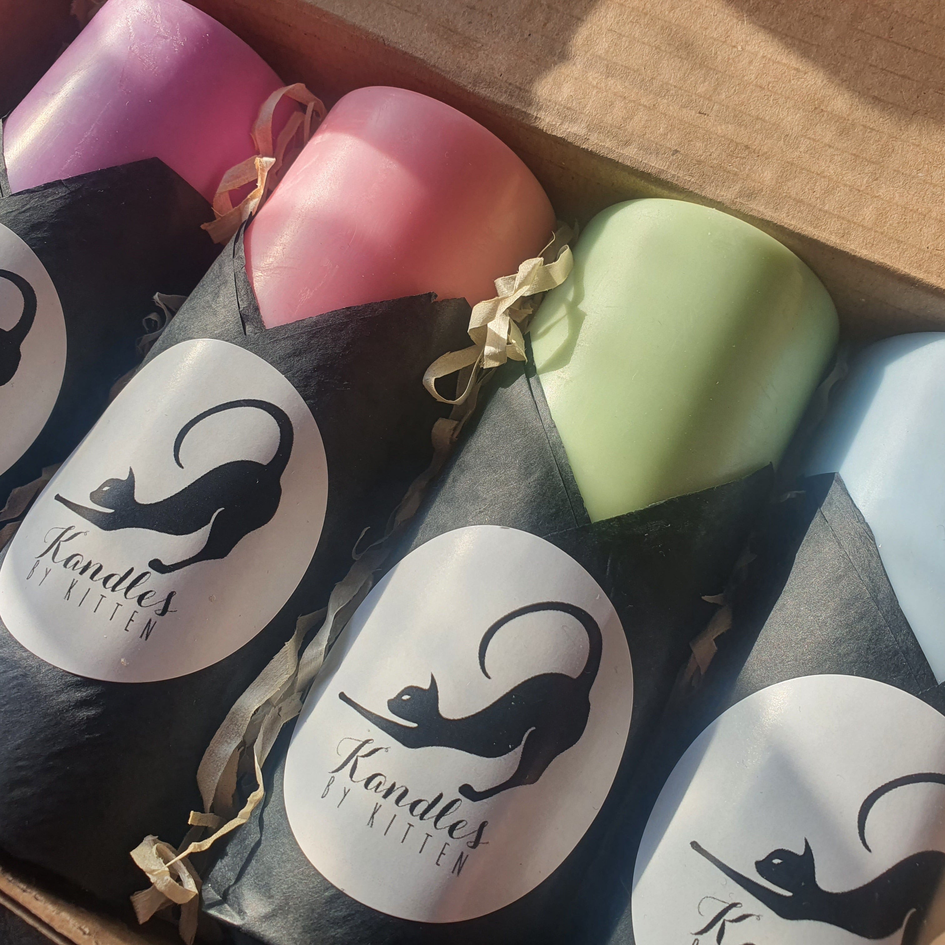 Set of colorful candles in a box with 'Kandle' branding.